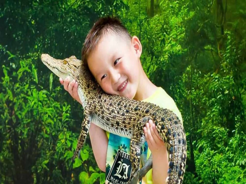 Children holding a crocodile at Crocodile Adventureland Langkawi